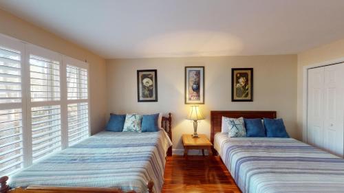 two beds in a room with two windows at Golf Lover's Haven Modern One-Bedroom Suites in Pawleys Island