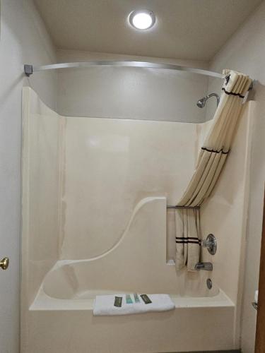 a bathroom with a shower with a shower curtain at Boomtown Inn in Drumright