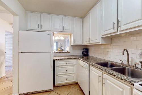 a white kitchen with a sink and a refrigerator at Pendleton in Eustis