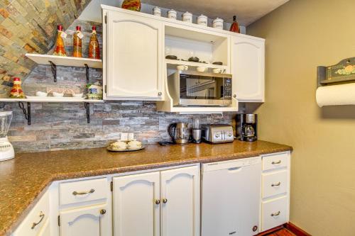 a kitchen with white cabinets and a microwave at Mountain-View Cabin in Pinetop with Fire Pit and Yard in Pinetop-Lakeside