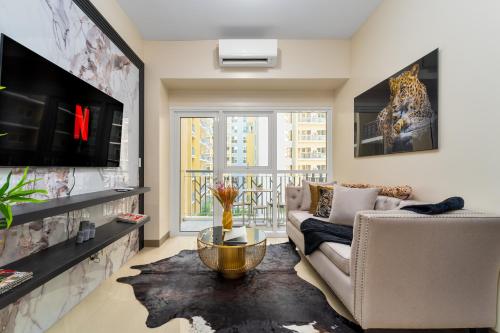 a living room with a couch and a tv at Luxury Condo Ocean View 1,2,3, & 4 Bedrooms Infinity Pool Gym Spa Next to Okada Solaire MOA NAIA Airport in Manila