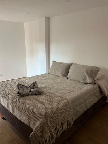 a bed with a bow on it in a bedroom at Apartamento Marquesa in Villa de Leyva