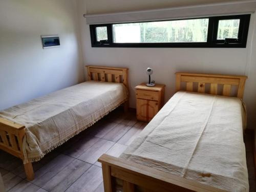 a bedroom with two beds and a window at Cabaña Coyam in Villa del Dique