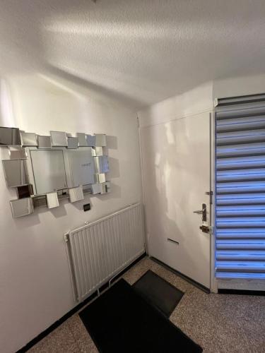 Cette chambre blanche dispose d'une porte et d'une fenêtre. dans l'établissement Maison 8 personnes, à Faches-Thumesnil
