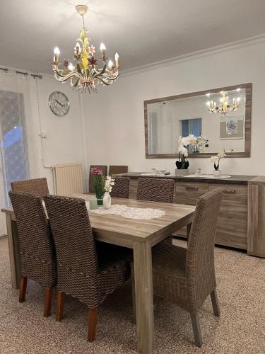 une table à manger avec des chaises et un lustre dans l'établissement Maison 8 personnes, à Faches-Thumesnil