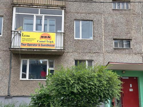 a sign on the side of a brick building at Camel Track Guesthouse and Tour Operator LLC in Ulaanbaatar