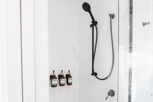 a bathroom with a shower with two bottles on the wall at Red Rock Hut, King Island in Yambacoona