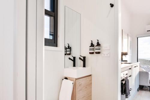 a white kitchen with a sink and a window at Red Rock Hut, King Island in Yambacoona