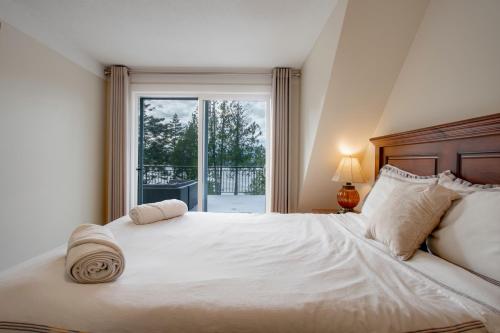 a bedroom with a large white bed and a window at Oceanfront Getaway in Sooke