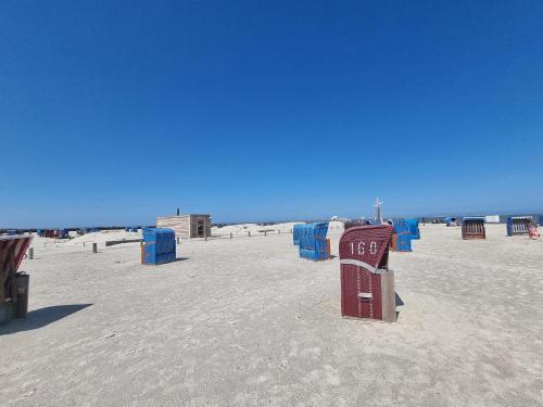 a beach with blue beach equipment on the sand at Ferienappartment Weisse Düne in Norden