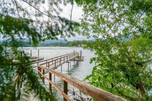 a wooden dock on a lake with trees at Oceanfront Getaway in Sooke