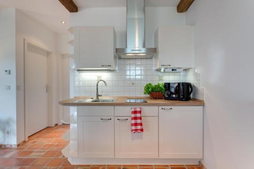 a kitchen with white cabinets and a sink at Spreewaldferienwohnungen in Lübben