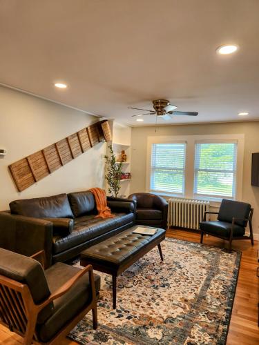 a living room with a leather couch and chairs at Backyard Bliss in the White Mountains in Lincoln