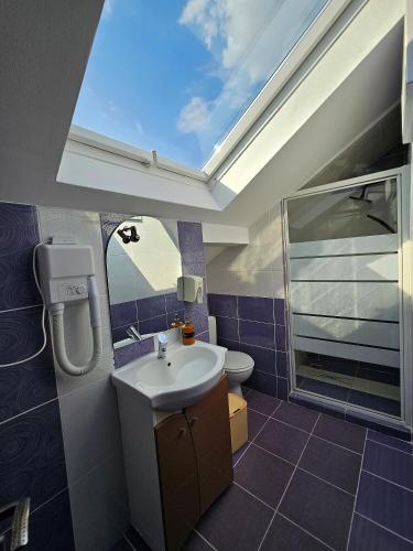 a bathroom with a sink and a skylight at Iris SMART Boutique Self Check-in 24h in Otopeni