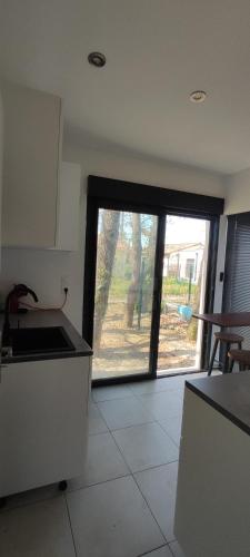 - une cuisine avec vue sur une grande fenêtre dans l'établissement Maisonnette avec jardin, à Colomiers