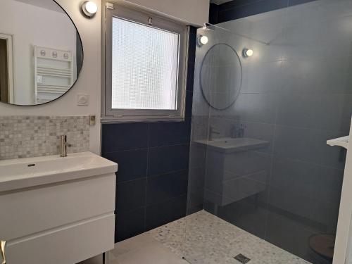 une salle de bain avec un lavabo et un miroir dans l'établissement Grande Maison Familiale Proche Plage, Piscines et Commerces – Idéal pour 8 Personnes - FR-1-323-546, à Saint-Jean-de-Monts