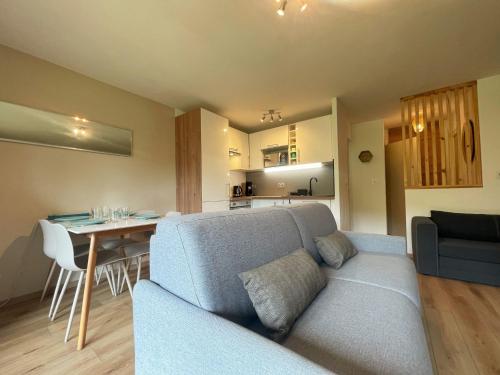 un salon et une cuisine avec un canapé et une table dans l'établissement Studio Cosy Proche Centre de Samoëns, Balcon, Parking & Proche Ski-Bus, Rénové avec Goût - FR-1-624-159, à Samoëns