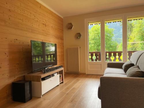 un salon avec un canapé et une télévision à écran plat dans l'établissement Studio Cosy Proche Centre de Samoëns, Balcon, Parking & Proche Ski-Bus, Rénové avec Goût - FR-1-624-159, à Samoëns