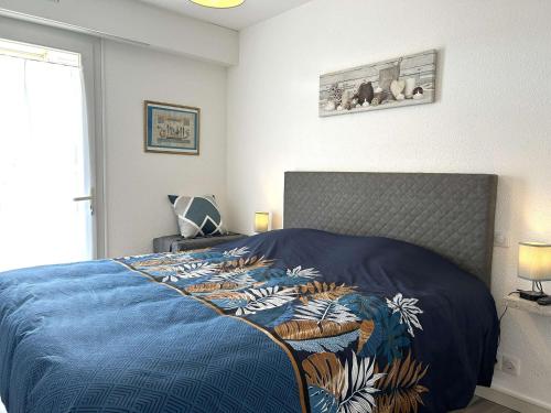 une chambre avec un lit avec une couette bleue dans l'établissement Charmant 2 pièces, 4 couchages, balcon, parking, à 2 pas de la Grande Plage de Saint-Gilles-Croix-de-Vie - FR-1-224-813, à Saint-Gilles-Croix-de-Vie