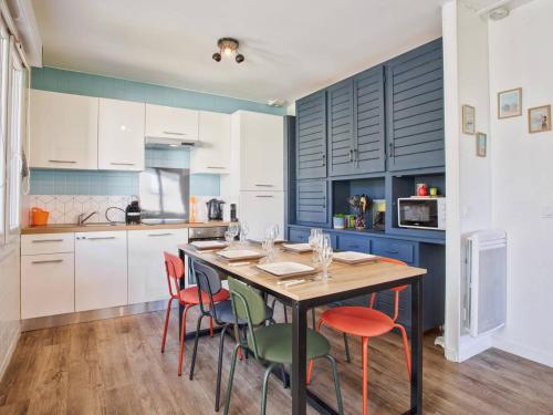 une cuisine avec une table et des chaises en bois dans l'établissement Maison familiale spacieuse, au calme, proche commerces et plage, avec jardin et terrasse. - FR-1-788-24, à Merville-Franceville-Plage