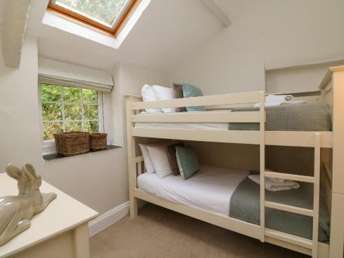 ein kleines Zimmer mit Etagenbetten in einem Haus in der Unterkunft Pheasant Cottage in Ilfracombe