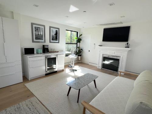 Una sala de estar con chimenea y televisión. en Modern Bright New Studio with Roof-top Deck Walk to Santa Monica Beach, FreeWiFi, Parking, en Santa Monica