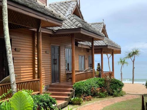 a house on the beach with the ocean in the background at Baan Pakgasri Hideaway in Ko Lanta