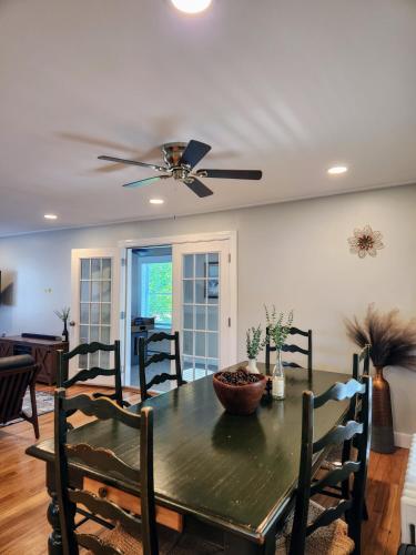 a dining room with a table and a ceiling fan at Backyard Bliss in the White Mountains in Lincoln