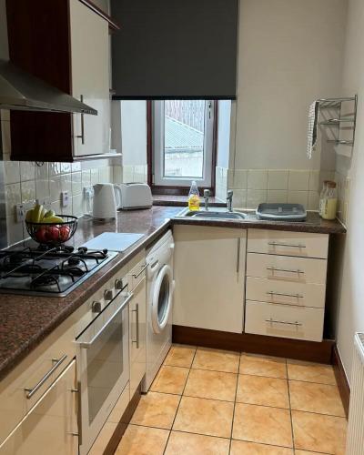 a kitchen with a sink and a stove top oven at MacIver City Apartment Academy Street in Inverness