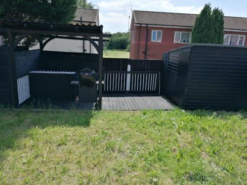 a backyard with a black fence and a gazebo at Affluent Living Property perfect for contractors and individuals in Wigan