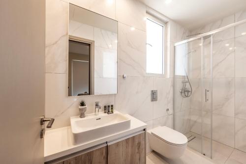 a bathroom with a sink and a toilet and a shower at Protaras Mythical Seas in Protaras