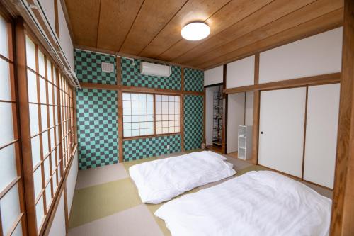 a bedroom with two beds in a room at 巴ドットcom Premium Stay in Hakodate