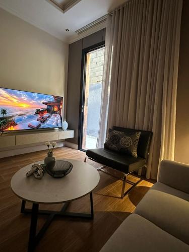 a living room with a tv and a couch and a table at استديو بتجربه فريده مع جلسه خارجيه in Riyadh