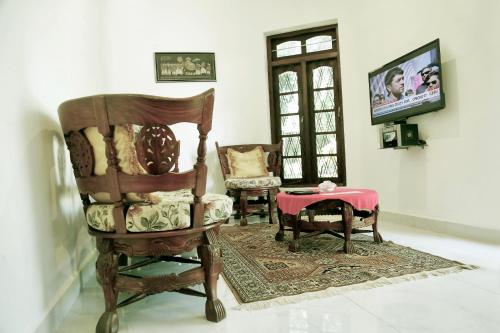 a living room with a chair and a table at Gert's Aerovista villa in Seeduwa