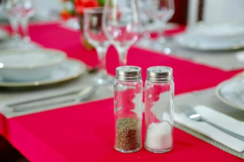 a red table with two glass jars filled with food at Gert's Aerovista villa in Seeduwa
