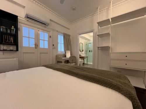 a bedroom with a large white bed and a desk at Floriana Boutique Hotel in Cairns