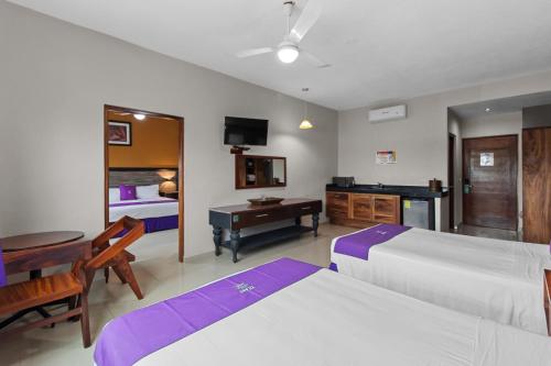 a bedroom with two beds and a desk and a television at Hotel Yeah Rinc&oacute;n de Guayabitos in Rincon de Guayabitos