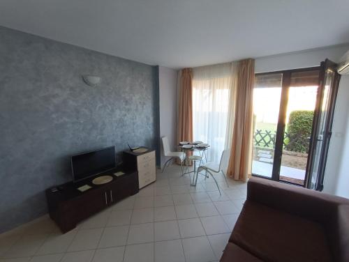 a living room with a couch and a television at Oasis beach house , apartment Nevena in Lozenets
