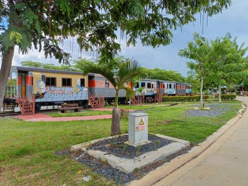 a group of train cars parked in a park at Tayama Farm Khaoyai in Nakhon Ratchasima