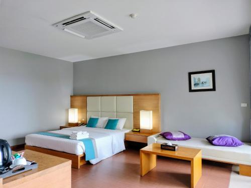 a hotel room with two beds and a television at Chang Buri Resort & Spa in Ko Chang