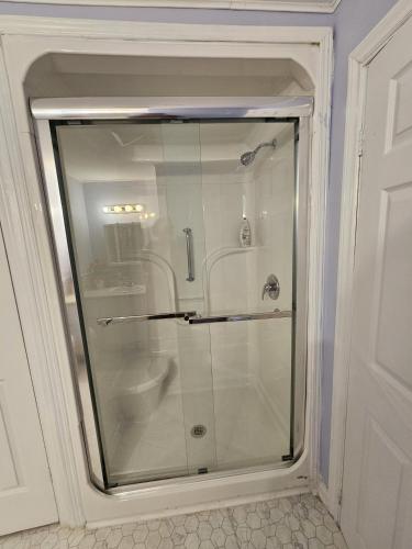 a glass shower door in a bathroom with a toilet at Blue Ocean Family vacation Luxury Suite in Halifax