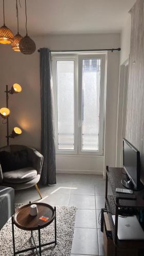 un salon avec un canapé et une table dans l'établissement Aux pieds du stade de France, à Saint-Denis