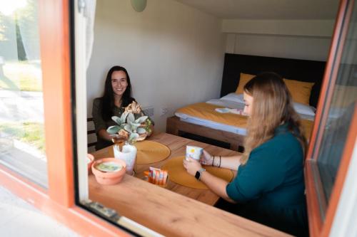 two women sitting at a table in a room at Rodinné chaty MORAVANPARK - Ubytování v srdci Valašska in Podkopná Lhota