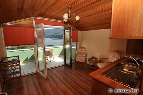 アマスラにあるエミン アパート ペンションのキッチン、プールの景色を望むリビングルームが備わります。