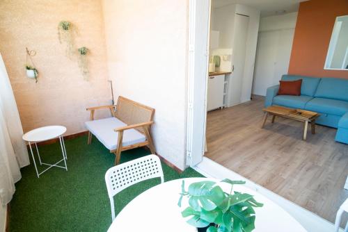 un salon avec un canapé bleu et une table dans l'établissement T2 Les Dauphins Giens, à Hyères