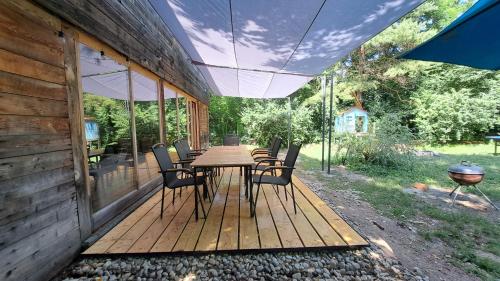 a wooden deck with a table and chairs on it at Szentendrei sziget, modern faház, télen is in Szigetmonostor