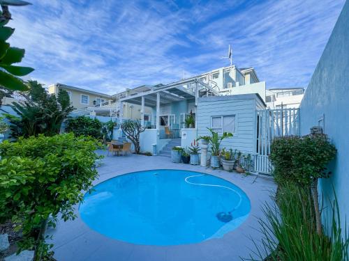 a small blue swimming pool in front of a house at Amoris In Sea Point in Cape Town