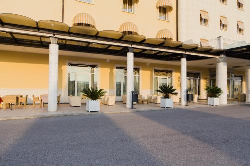 a building with a patio with chairs and plants at Zanhotel Centergross in Bentivoglio