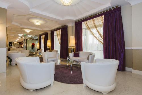 a living room with white chairs and a table at Zanhotel Centergross in Bentivoglio