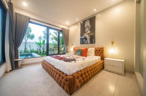 una camera da letto con un letto grande con una grande finestra di Cavara Villa Canggu a Canggu